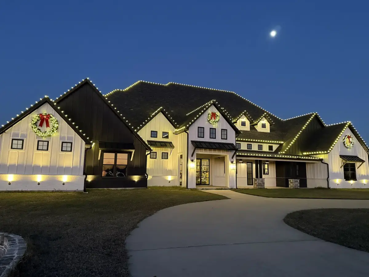 Two-story home decorated with Christmas lights and garland
